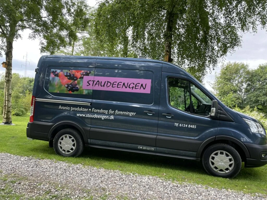 Staudeengens mørkeblå minibus med påskriften Aronia produkter og foredrag for foreninger.